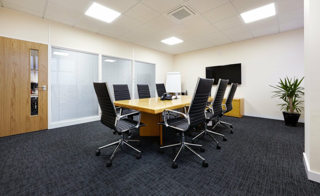 Office board room with large wooden table and black executive chairs