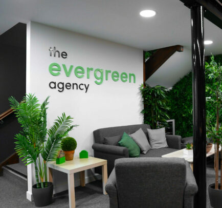 office reception area with grey sofas and plants in pots