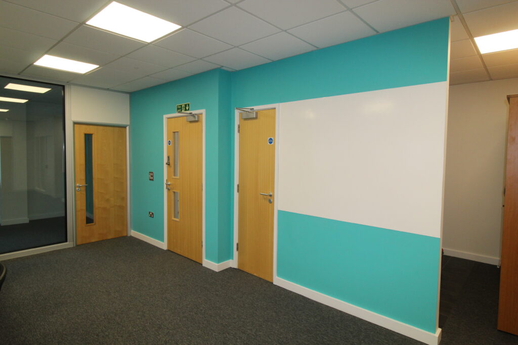 Grey carpet, glass partition, painted wall with writable finish