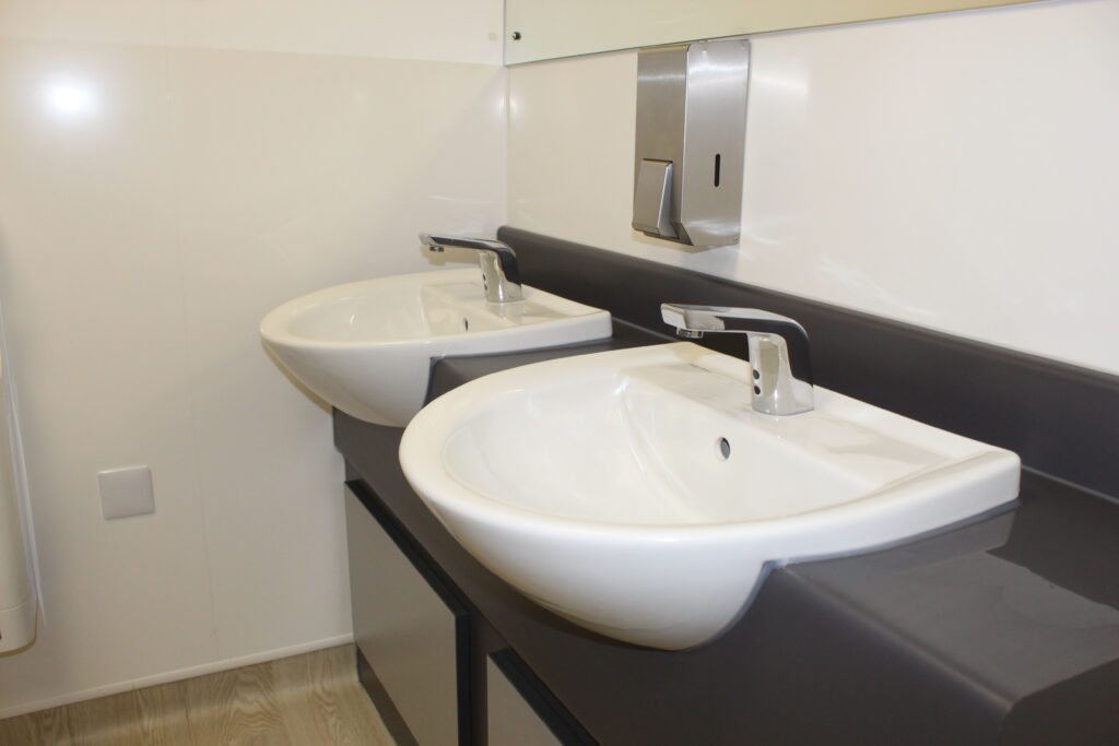 Washroom sinks with soap dispenser