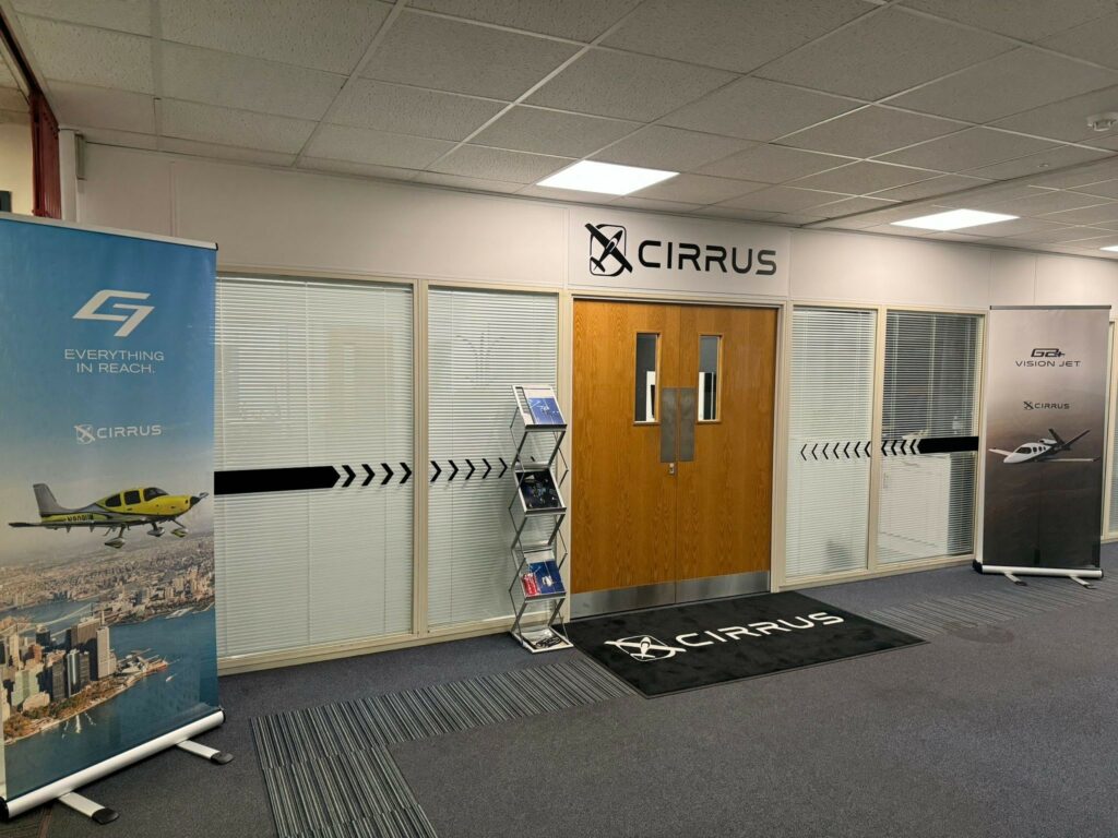 Pair of double doors with vision panels. Cirrus brand graphics on the door mat and above the door.