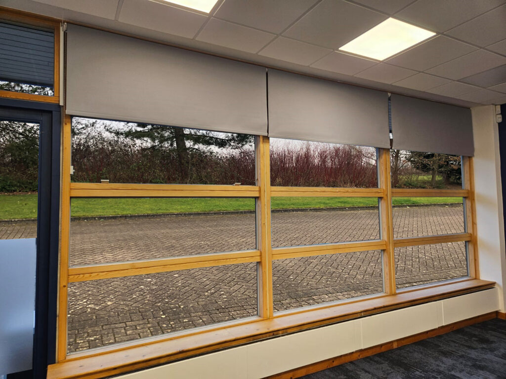 Office windows with grey roller blinds