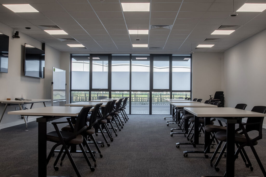 Training room desks and chairs laid out in a Town Hall format