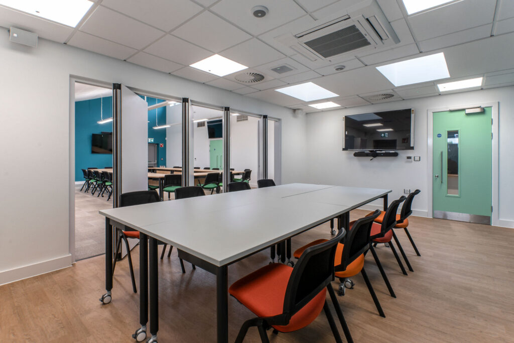 Large rectangular table and orange padded chairs