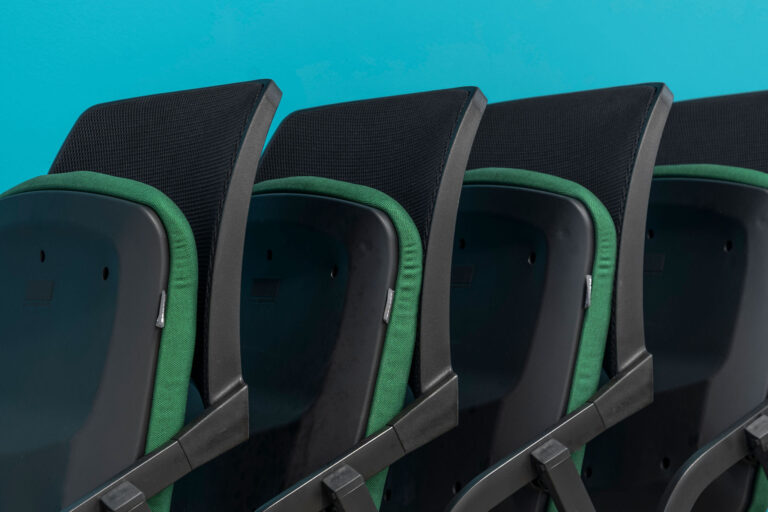 Close up image of Folded black chairs with green seat pads