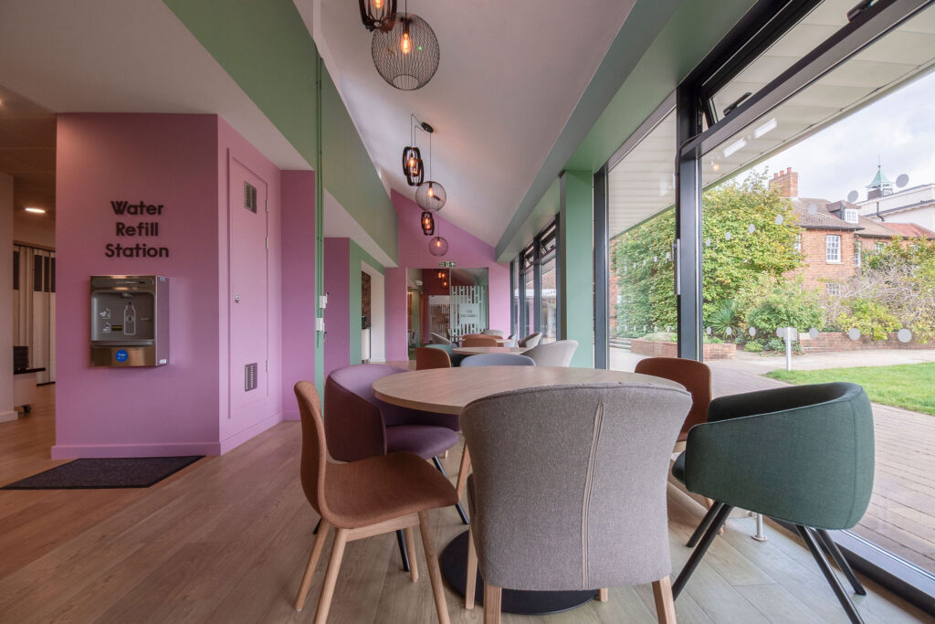 Coffee table with soft chairs in forground and pink walls
