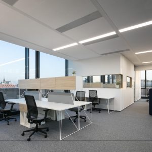 bright office with white desks, mesh backed task chairs and corner office partition